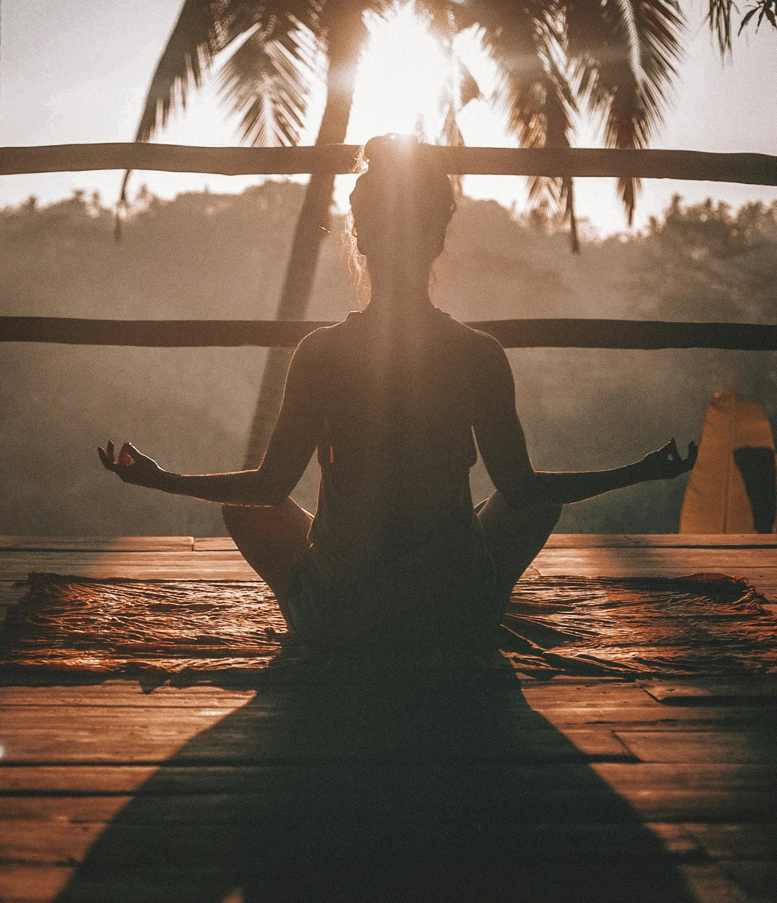 A person meditating in a peaceful setting at dawn