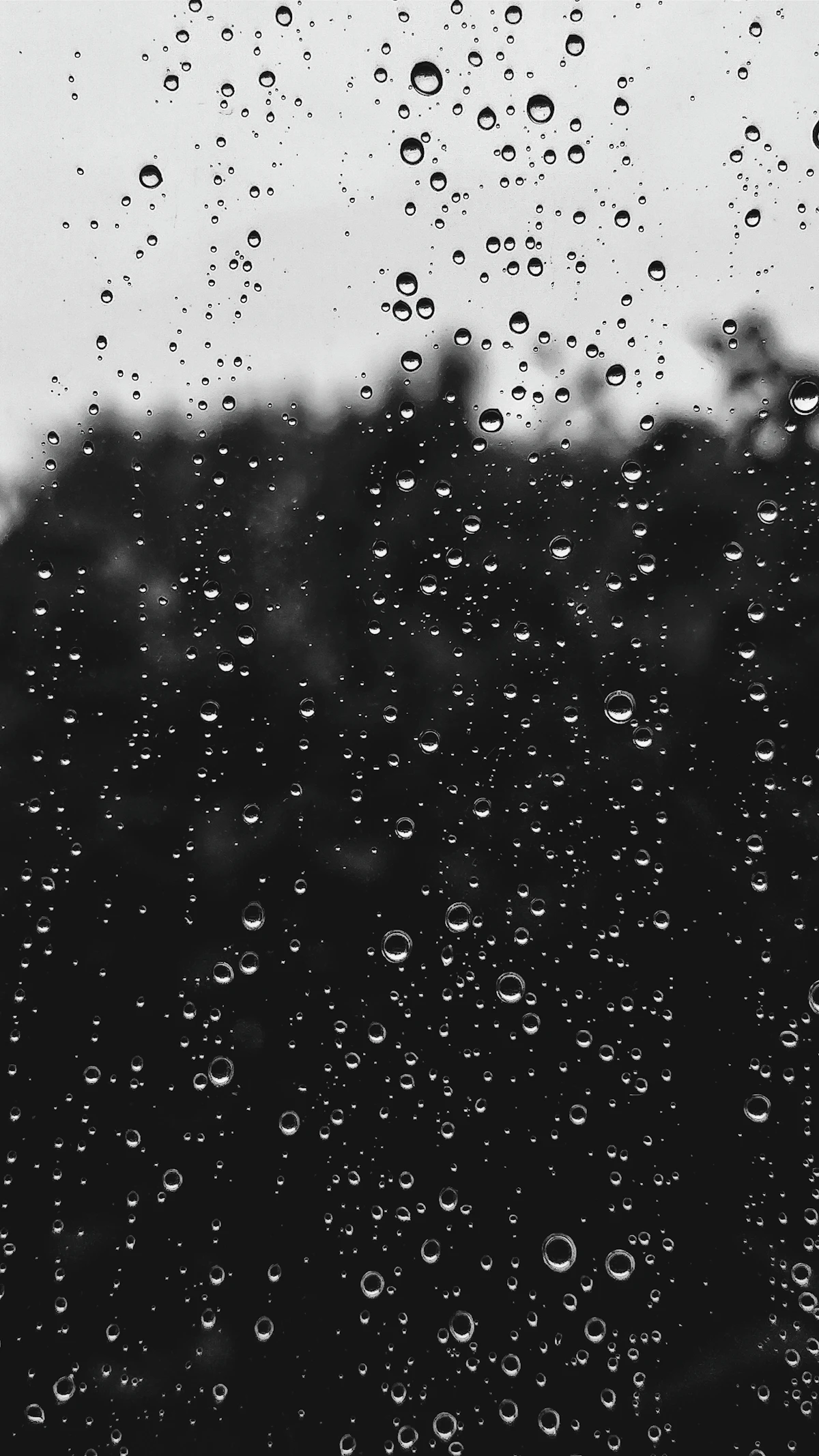 Rain drops on a window pane with blurred city lights